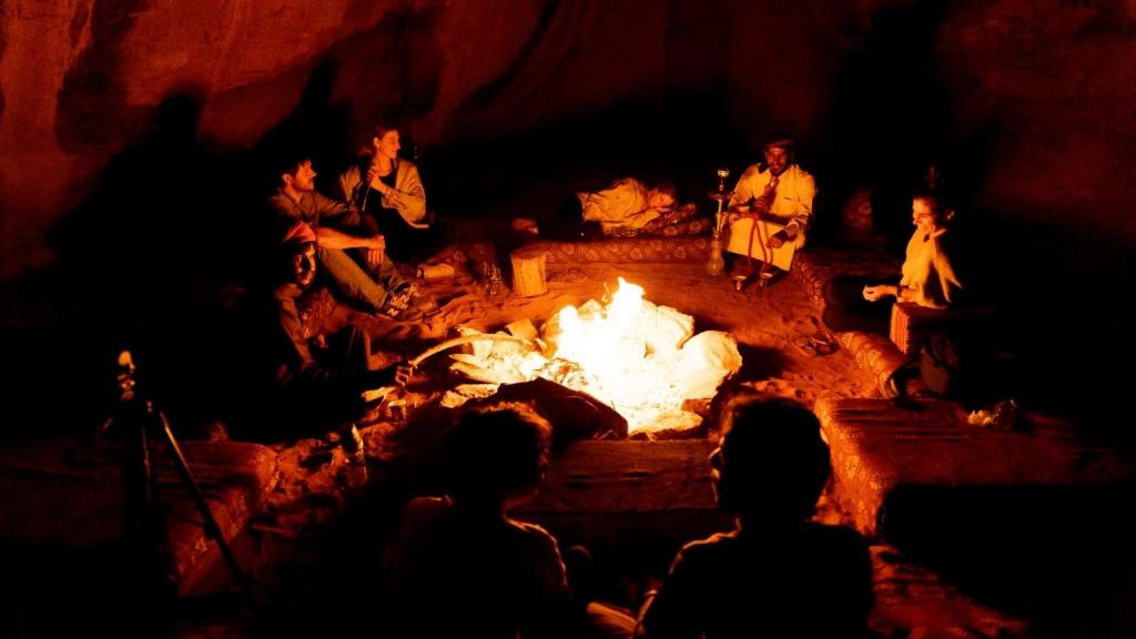 瓦迪拉姆Magic Bedouin Night的一群人围坐在火炉旁