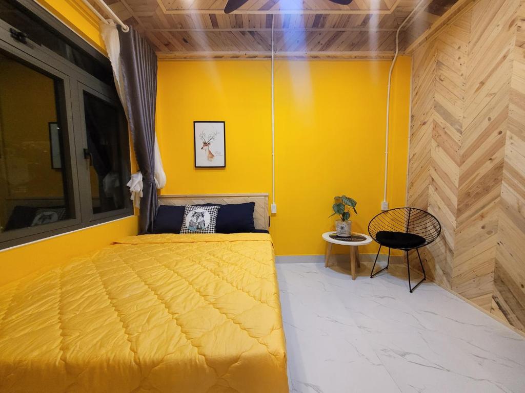 大叻Lightning House的黄色卧室,配有床和椅子