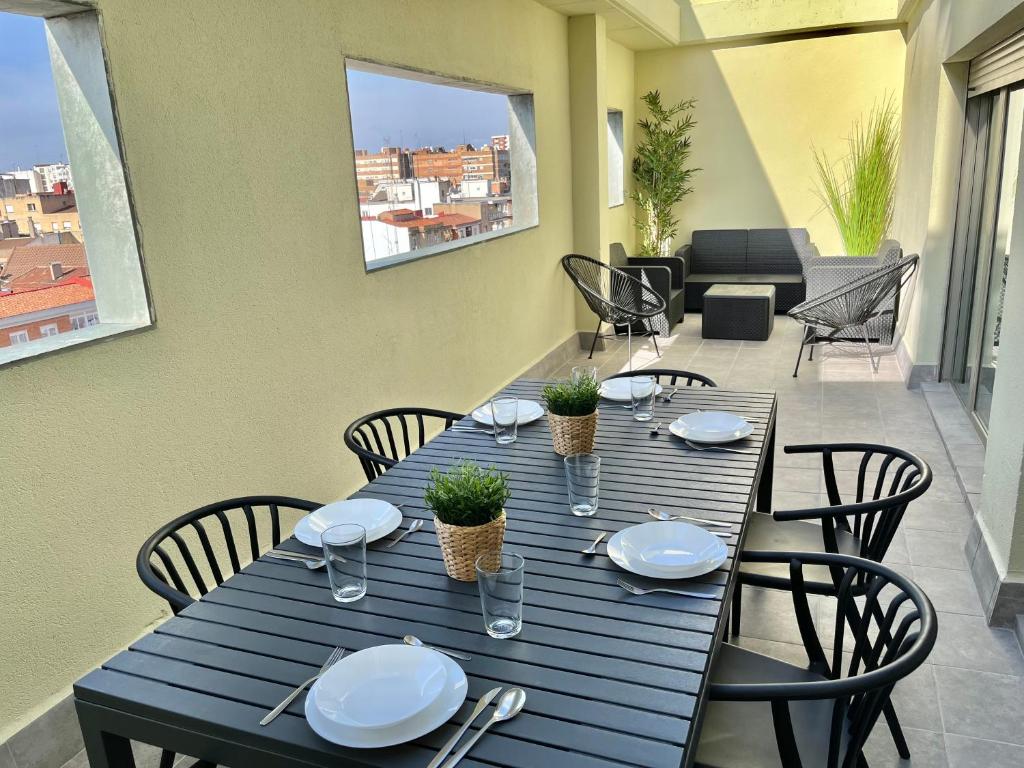 萨拉戈萨Apartamento Vive Zaragoza IV的一张带椅子和盘子的蓝色桌子