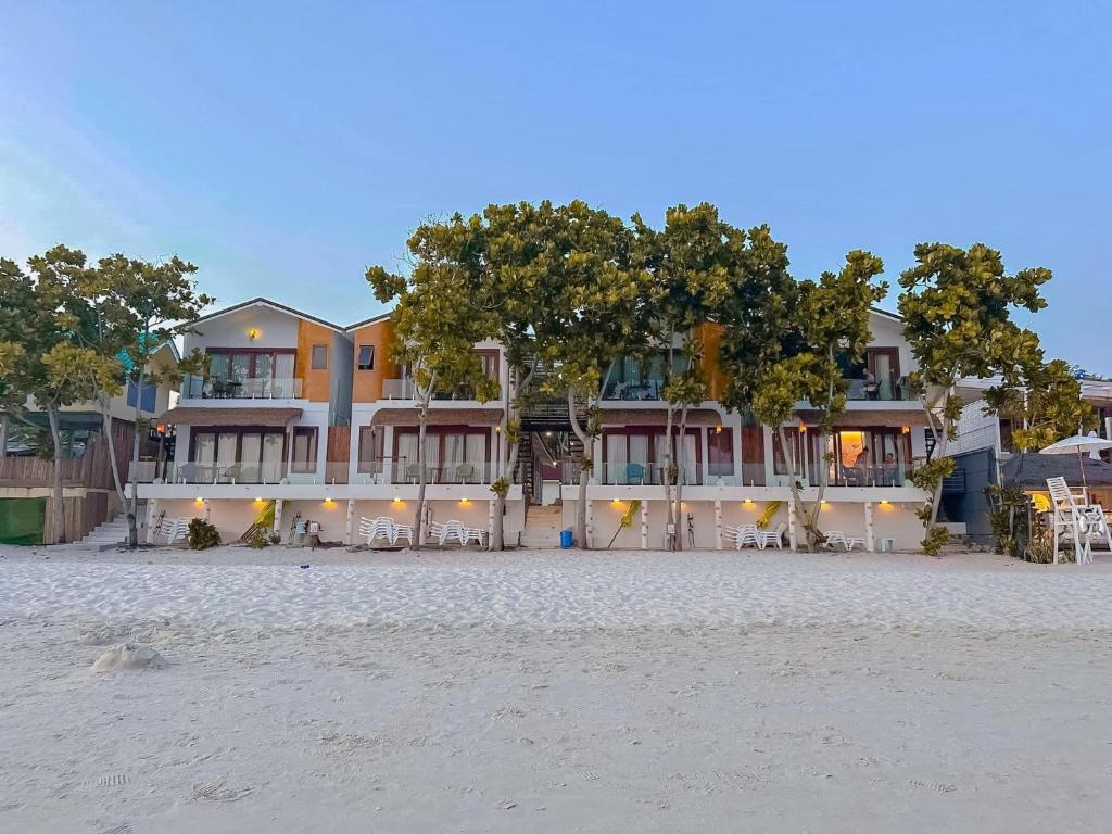 沙美岛Diamond Beach Resort的海滩上的一座建筑,有椅子和树木