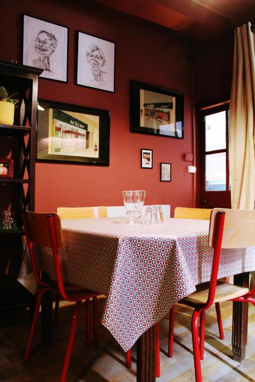 VicdessosEau Berges - Chez Mamie的一间带桌椅和红色墙壁的用餐室