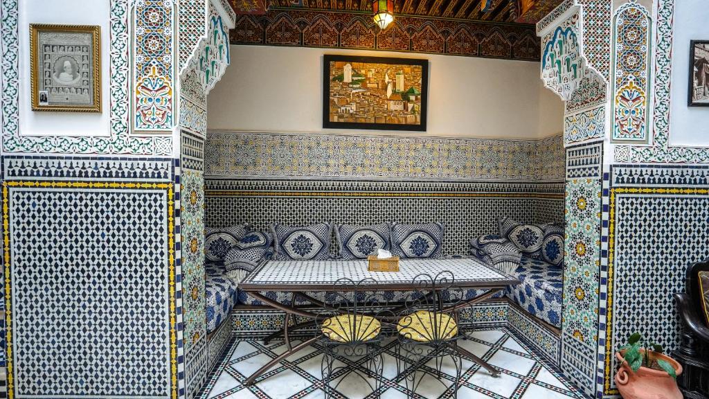 非斯Riad Green House的一间设有桌子和蓝色及白色瓷砖的客房