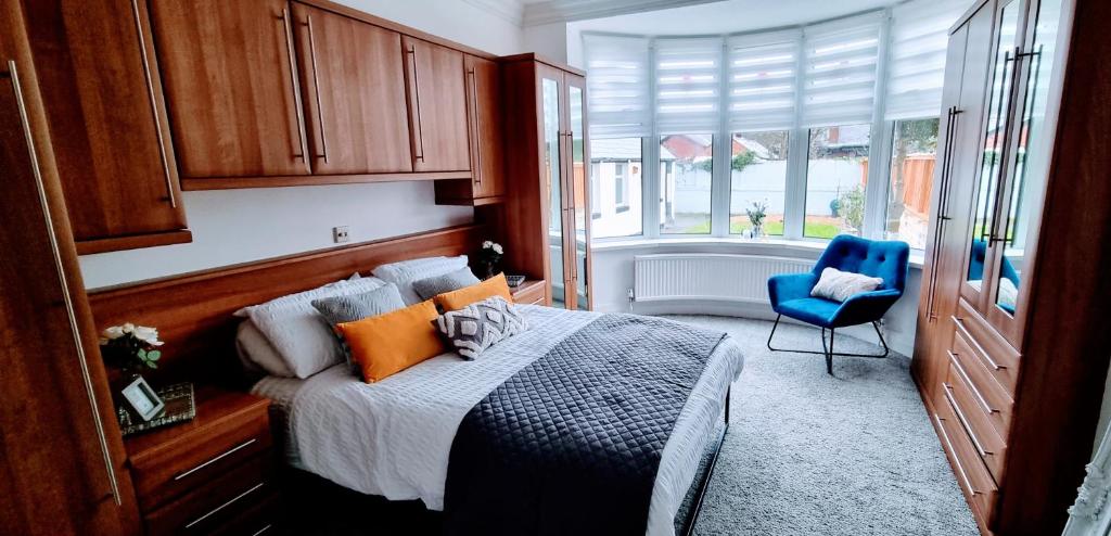 布莱克浦Oasis Holiday Home Blackpool的一间卧室配有一张床和一张蓝色椅子