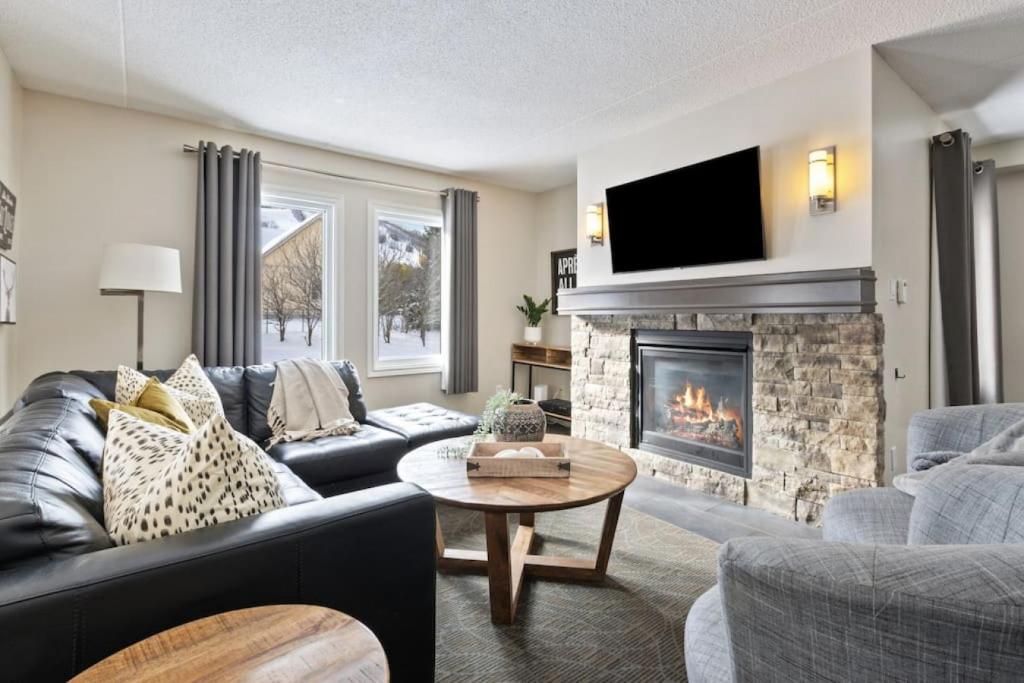 蓝山Blue Mountain Chalet Condo with Amazing Location的带沙发和壁炉的客厅