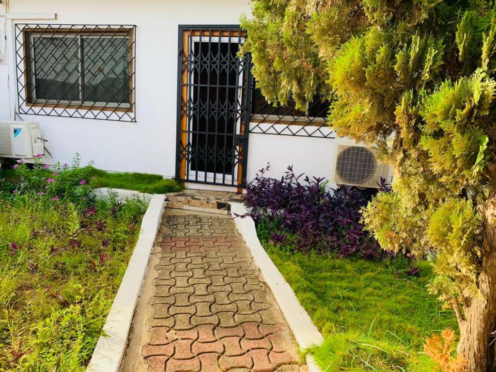 特马Stunning 1-Bed House in Tema- Oheneba villa的门口房子前面的走道