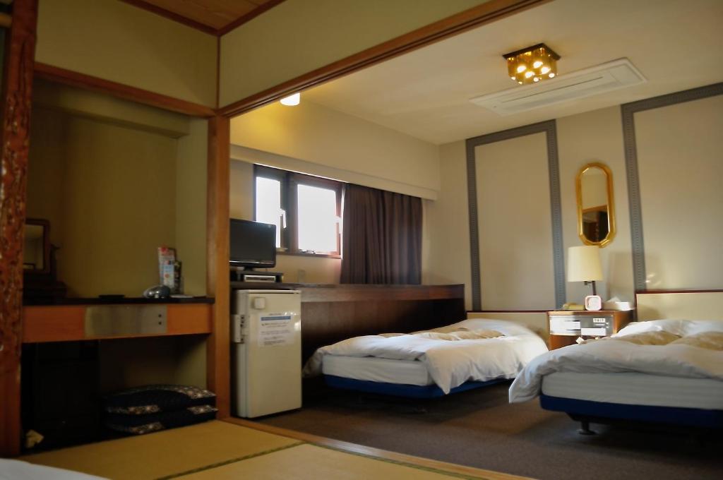 高知洛杉高知酒店的酒店客房设有两张床和电视。