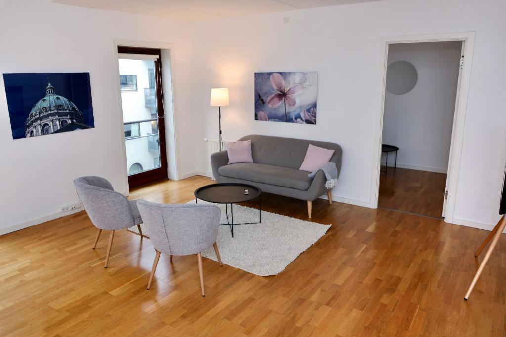 哥本哈根Scandi-Hygge 2 bedroom apartment in charming Christianshavn的客厅配有沙发和桌椅