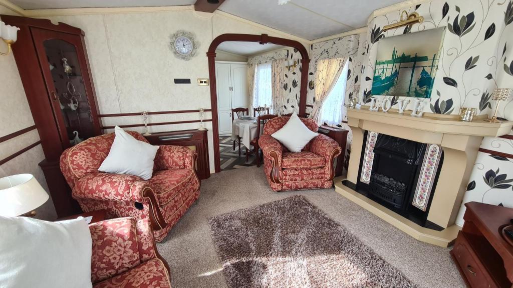 英戈尔德梅尔斯Caravan 6 berth的客厅配有两把椅子和壁炉
