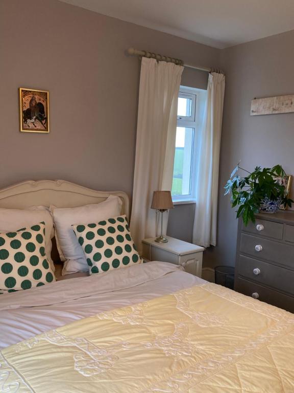 金斯布里奇Hope Valley House的卧室配有带枕头的床铺和窗户。