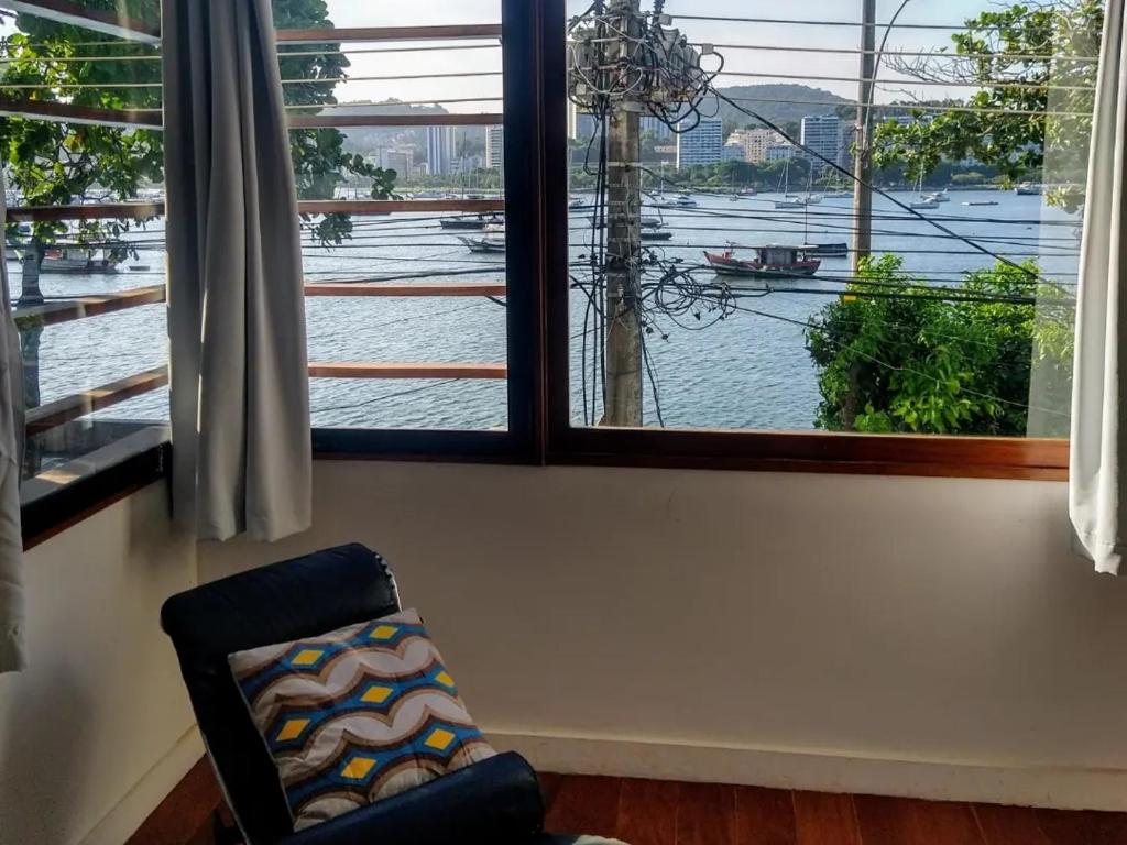 里约热内卢Luna Rossa Guest House的水景窗户前的椅子
