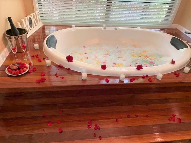 布德林姆爱茉莉在布德林姆热带雨林小屋酒店的铺有木地板的浴缸里装满了红色玫瑰花瓣