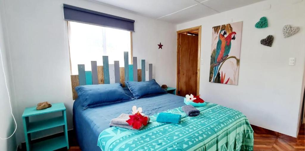 安加罗阿Henua Roa Loft的一间卧室配有蓝色的床和毛巾