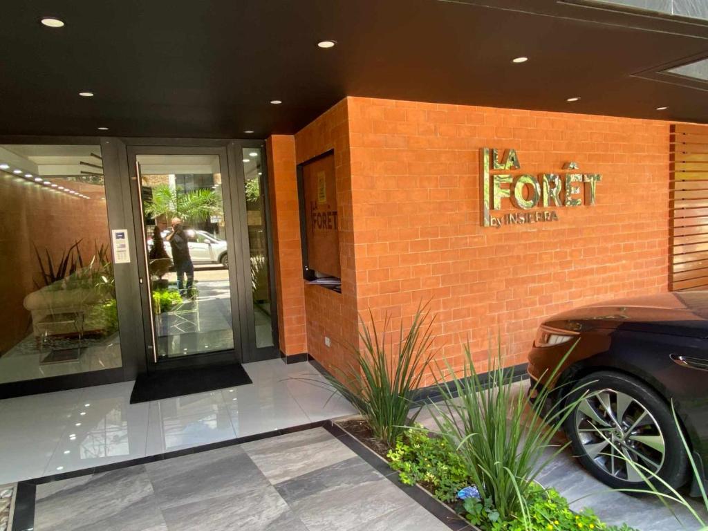 圣克鲁斯La Foret 2 dormitorios的外面有一间商店,有一辆汽车停在