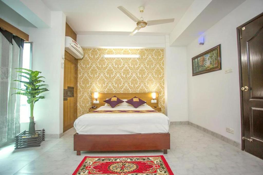 达卡Sel Nibash Hotel & Serviced Apartments的一间卧室配有一张大床和地毯。