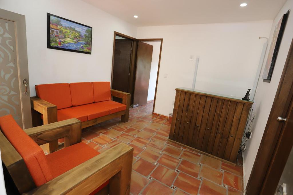 瓜达拉哈拉Hotel Boutique Casa Elefante的客厅配有橙色沙发和电视