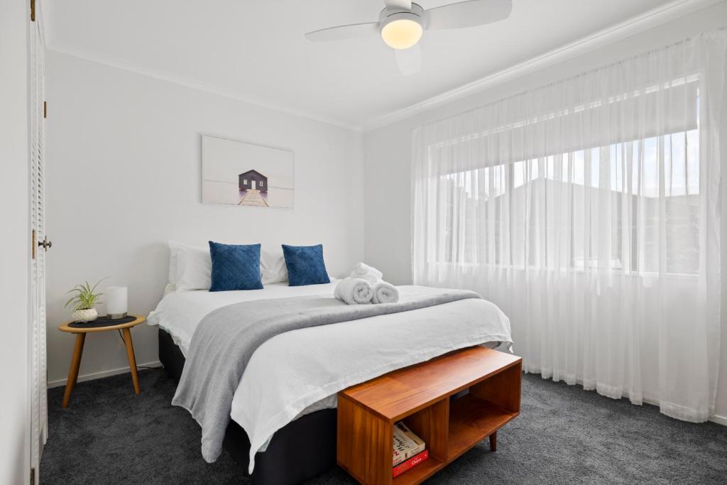 芒格努伊山Waitui Wonder - A Comfortable Escape的白色卧室配有一张带蓝色枕头的大床