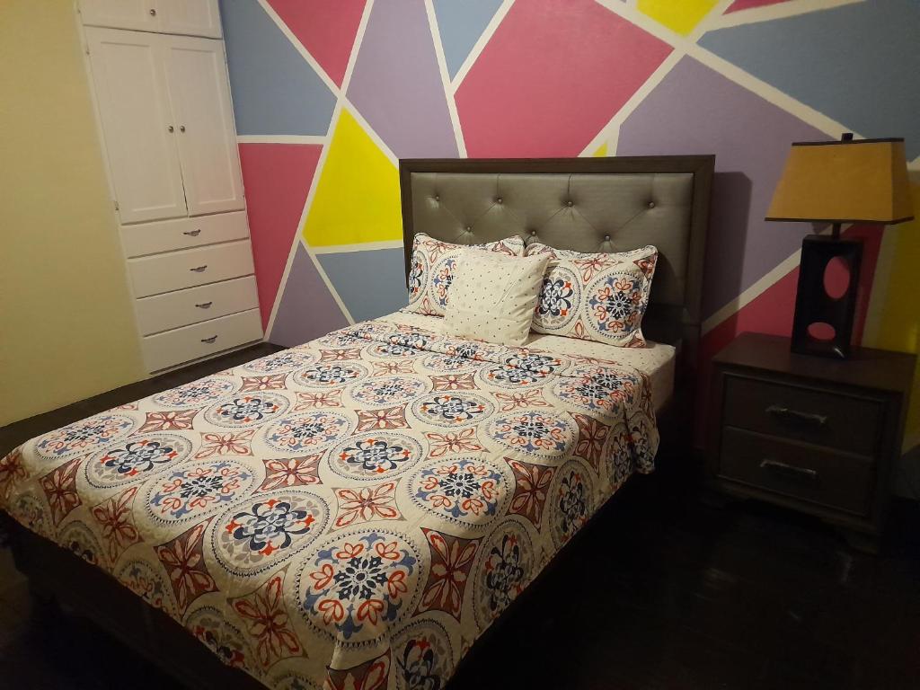 ChoiseulTropical Suites的一间卧室配有一张带彩色墙壁的床