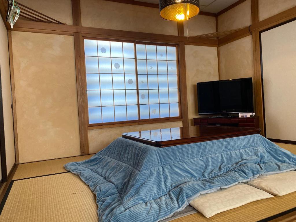关市Ishimaru House的一间带床和电视的客厅