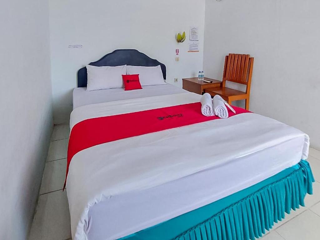 TanjungselorRedDoorz @ Tanjung Selor的一间卧室配有一张带红色毯子的大床