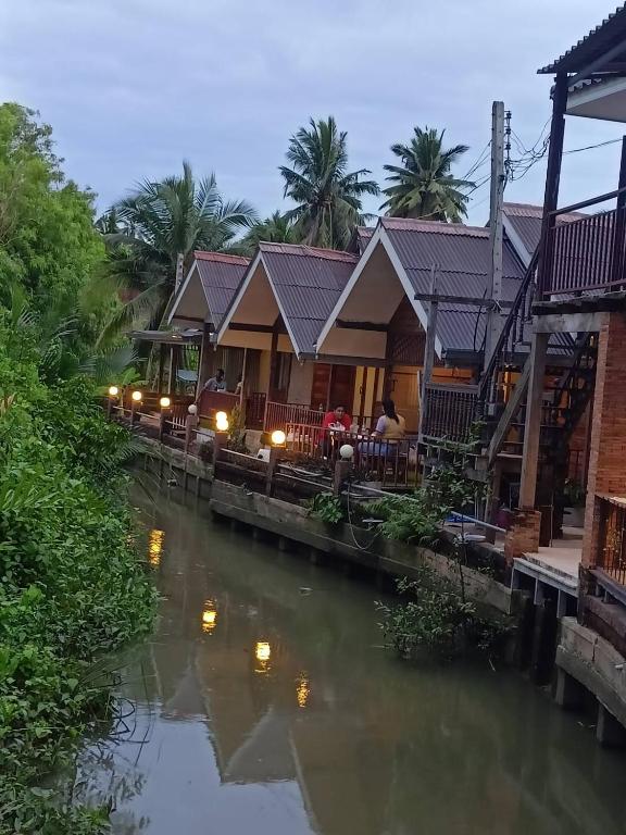 夜功府บ้านสุขใจ อัมพวา的河边的一排房子