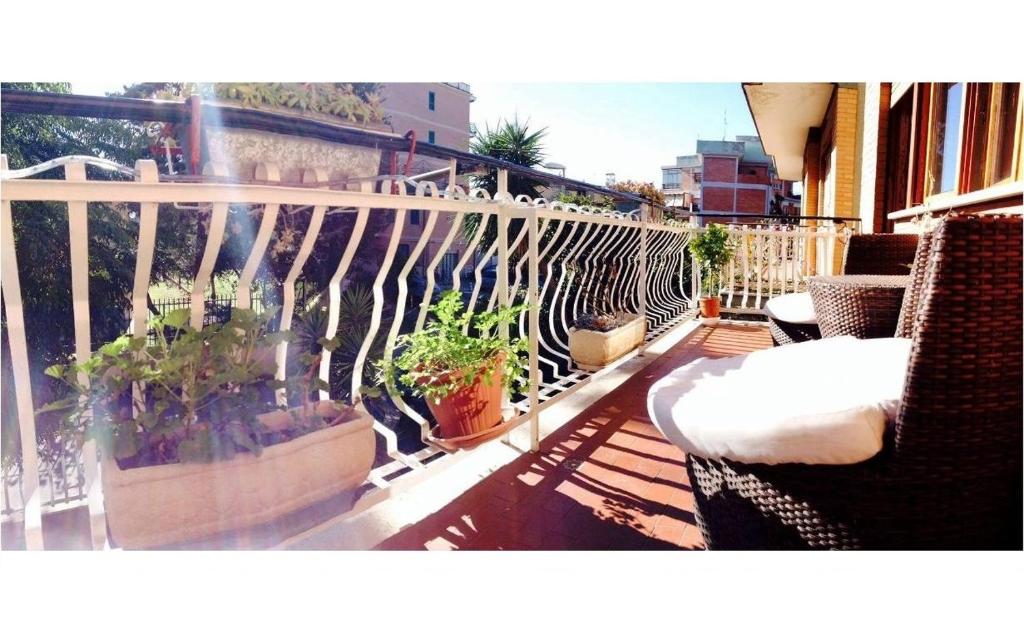罗马卡萨蔚酒店的大楼内的阳台配有椅子和盆栽植物