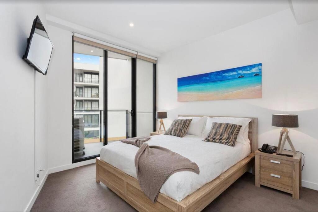 桑德灵厄姆Sandy Hill apartment, Sandringham的一间卧室设有一张床和一个大窗户