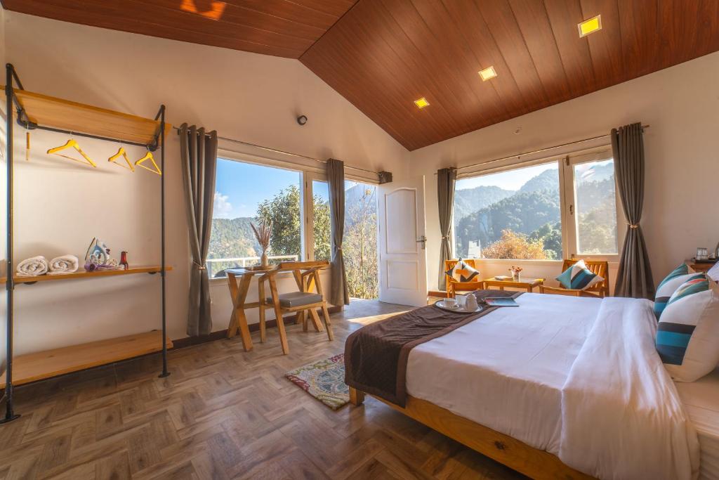 奈尼塔尔Zostel Plus Nainital (Naina Range)的一间带一张大床的卧室,位于带窗户的房间内