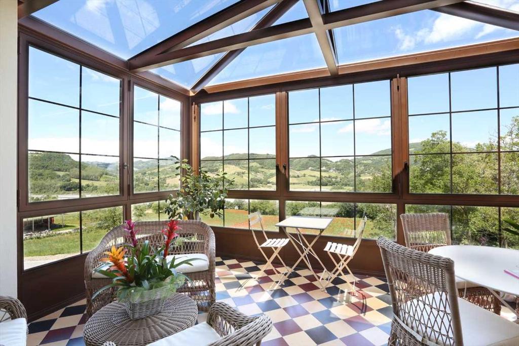 帕尔马Villa Gelsomina的温室配有桌椅和窗户