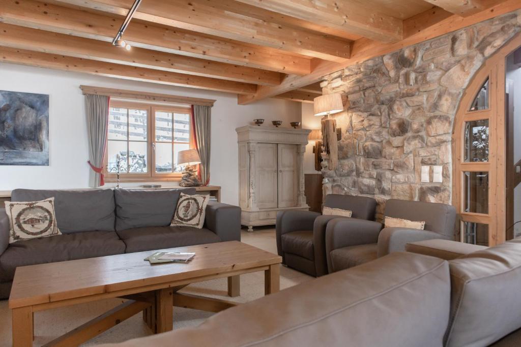 皮森多夫AvenidA Panorama Chalet by Alpin Rentals的带沙发和石墙的客厅