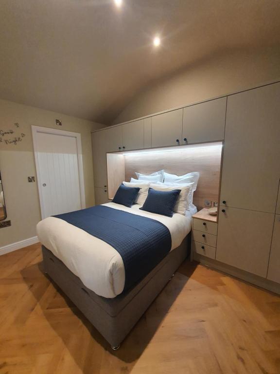 劳斯Wheelwright's Rest, Legbourne, Louth的一间卧室配有一张带蓝白色枕头的大床