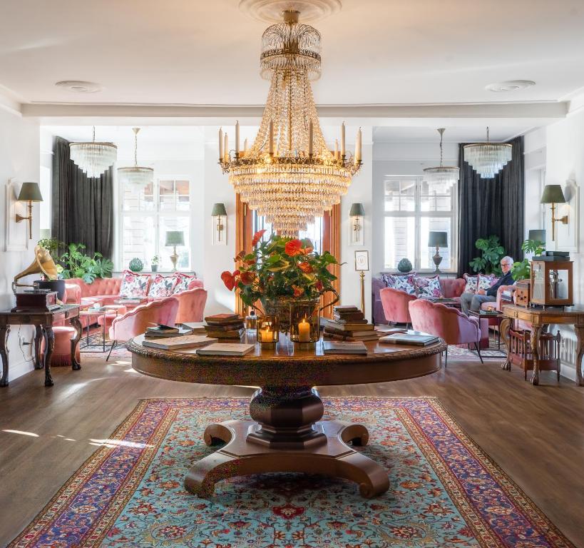 默勒Villa Brunnby的一个带吊灯和桌子的大客厅
