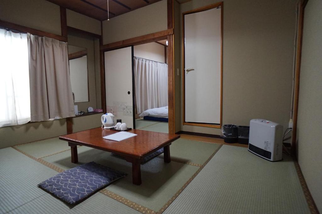 东京胜太郎日式旅馆的客厅配有桌子和床。
