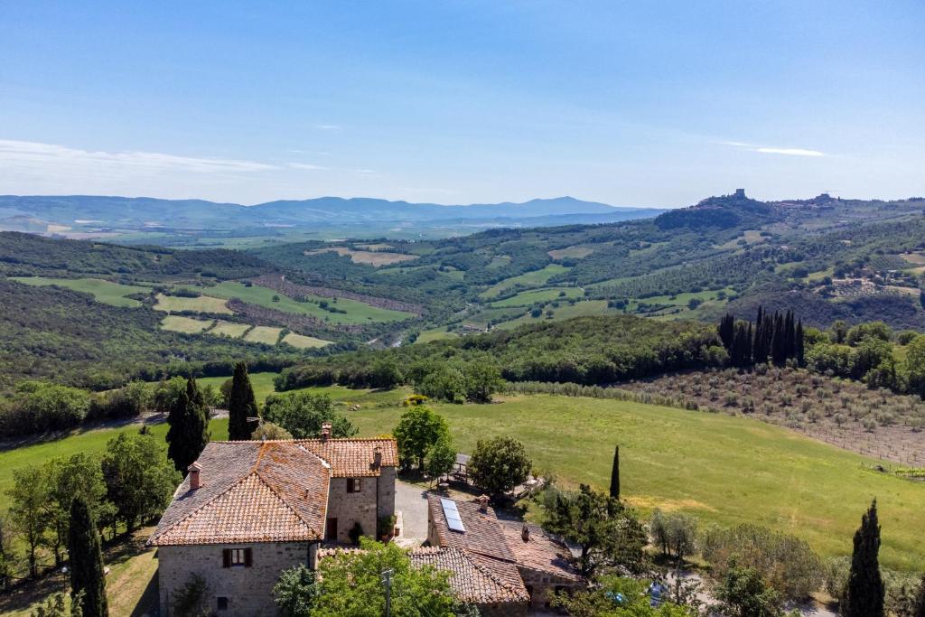 卡斯蒂戈隆·多尔希亚Agriturismo Il Poderuccio的绿色田野中农舍的空中景色