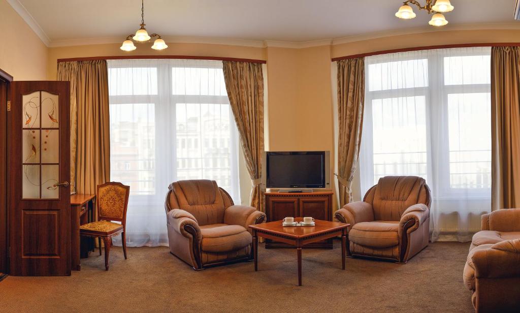 基辅迪尼普洛酒店的客厅配有椅子和平面电视