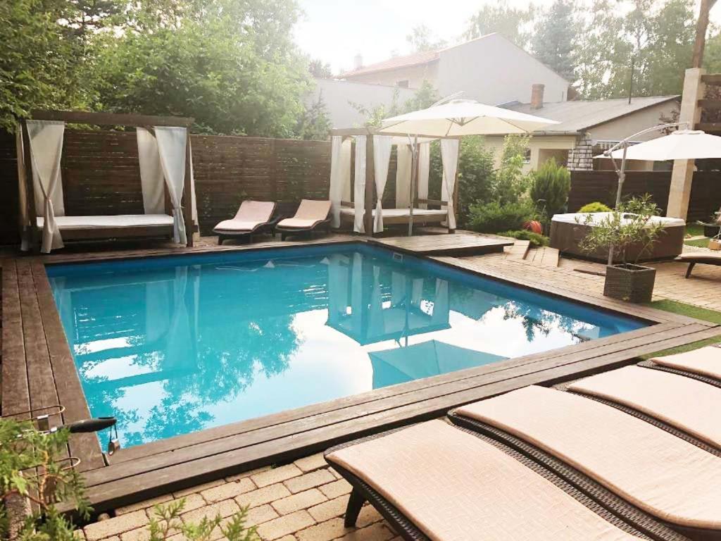 希欧福克银色花园旅馆的庭院内的游泳池配有椅子和遮阳伞