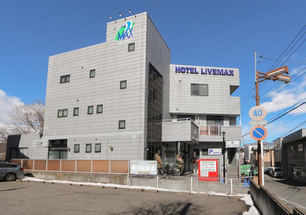 沼田HOTEL LiVEMAX BUDGET Gunma Numata的建筑的侧面有标志