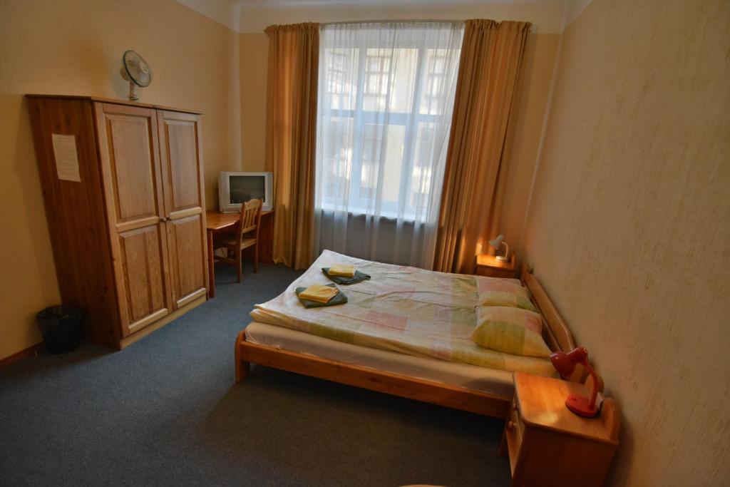 里加Hotel Multilux with Self Check-in的一间卧室配有一张床、一张书桌和一个窗户。