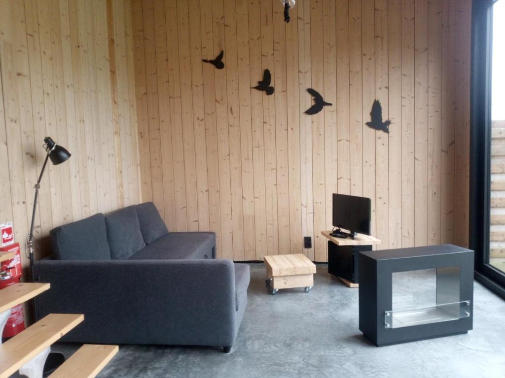 DuffelStation 25A的客厅配有沙发,墙上有鸟儿