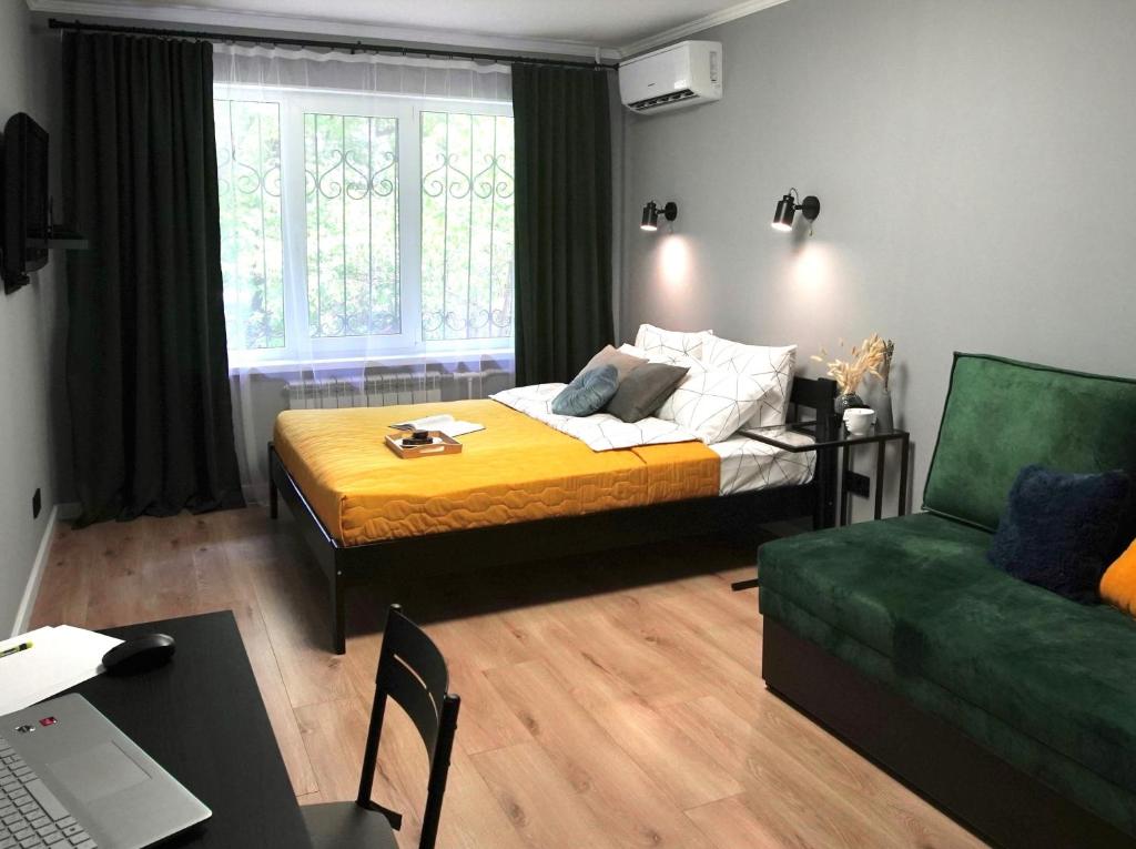 阿拉木图Almaty Aparts的一间卧室配有一张床和一张绿色沙发
