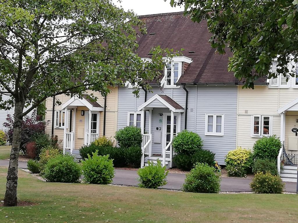 南塞尔尼Lovely Lakeside lodge for families and friends的白色的房子,有白色的门和树