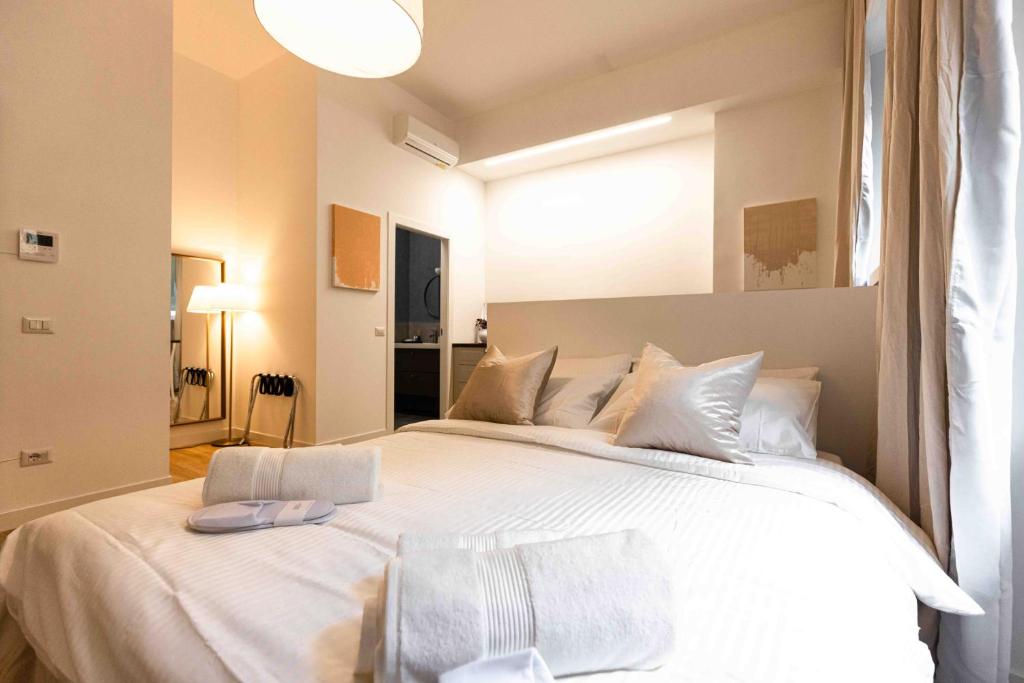 米兰Divini Gae Aulenti的卧室配有一张带白色床单和枕头的大床。
