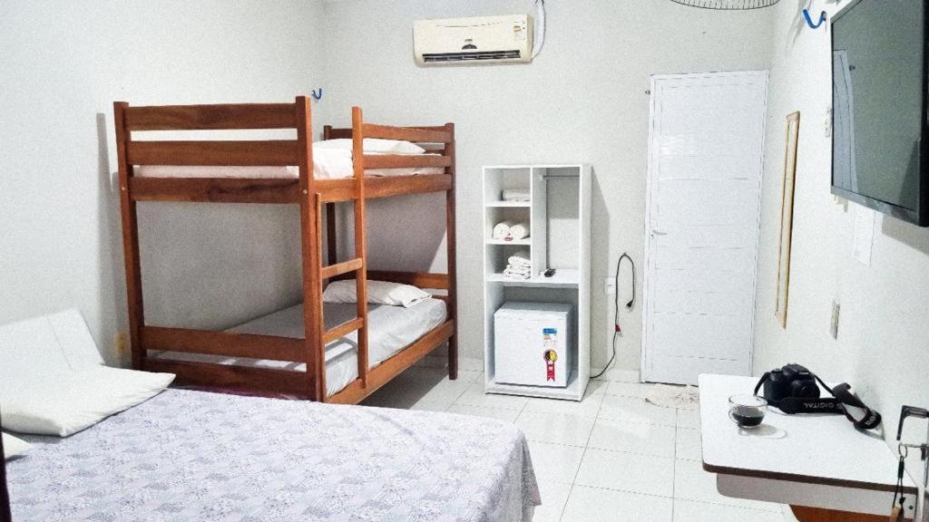 日若卡-迪热里科阿科阿拉Pousada Sol Dourado的客房设有两张双层床和一张书桌。