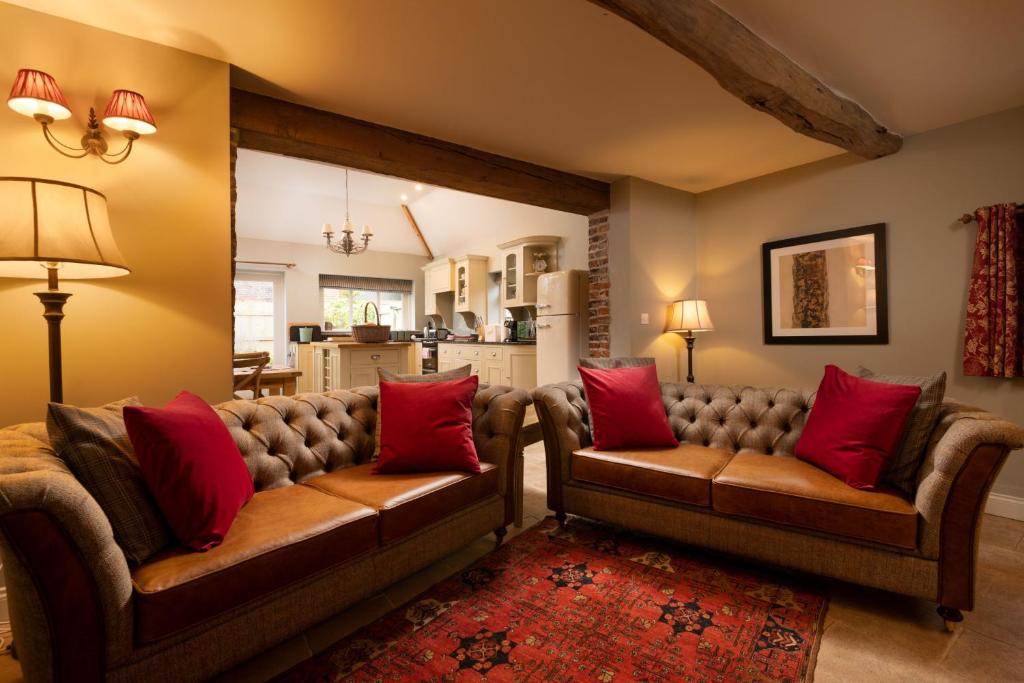 约克The Dovecote的客厅配有两张沙发和红色枕头