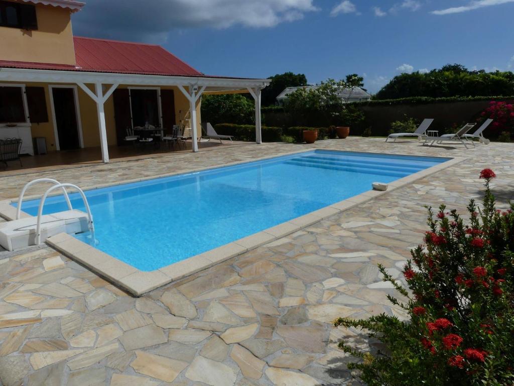拜马欧Villa Magnifique piscine & jardin的一座带石头庭院和房屋的游泳池