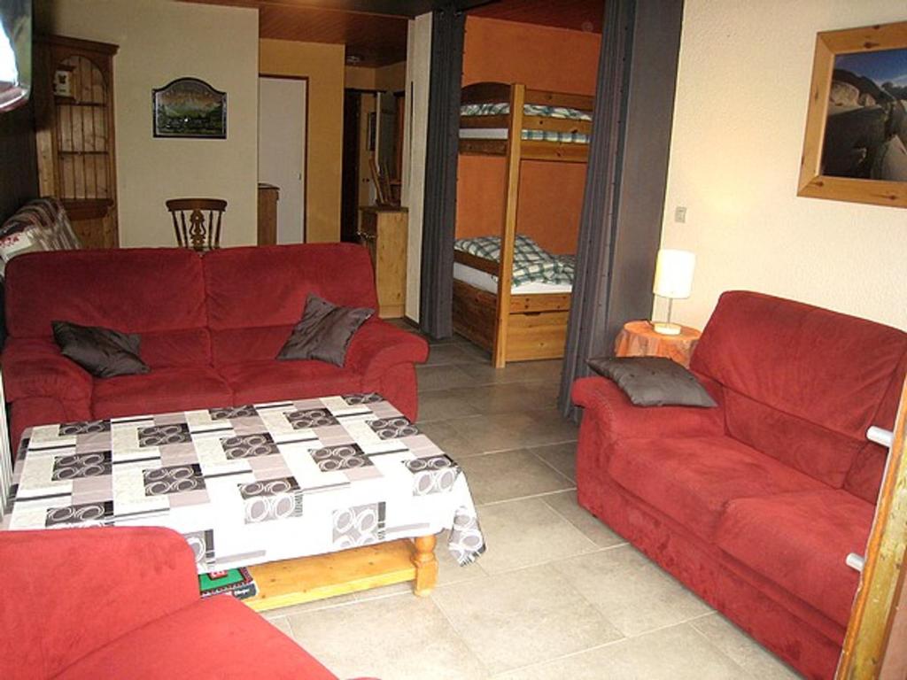 拉克吕萨Appartement La Clusaz, 3 pièces, 8 personnes - FR-1-459-5的客厅配有两张红色的沙发和一张床