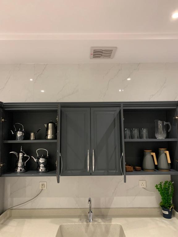 吉达سيلينا هاوس的厨房配有带锅碗瓢盆的黑色橱柜