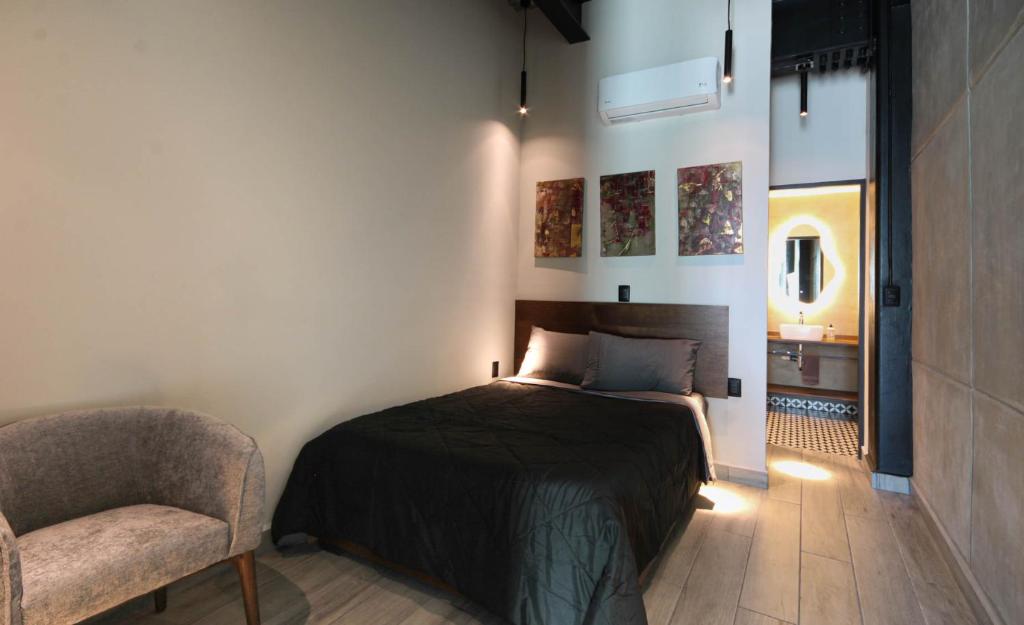 墨西哥城Hermoso y cómodo mini LOFT 3的一间卧室,卧室内配有一张床和一把椅子