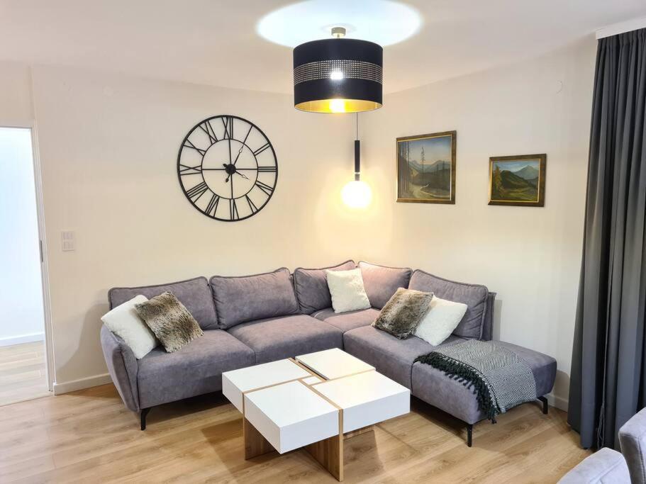 卡尔帕奇Rezydencja Green Hill - ekskluzywny dom w Karpaczu的客厅配有沙发和墙上的时钟