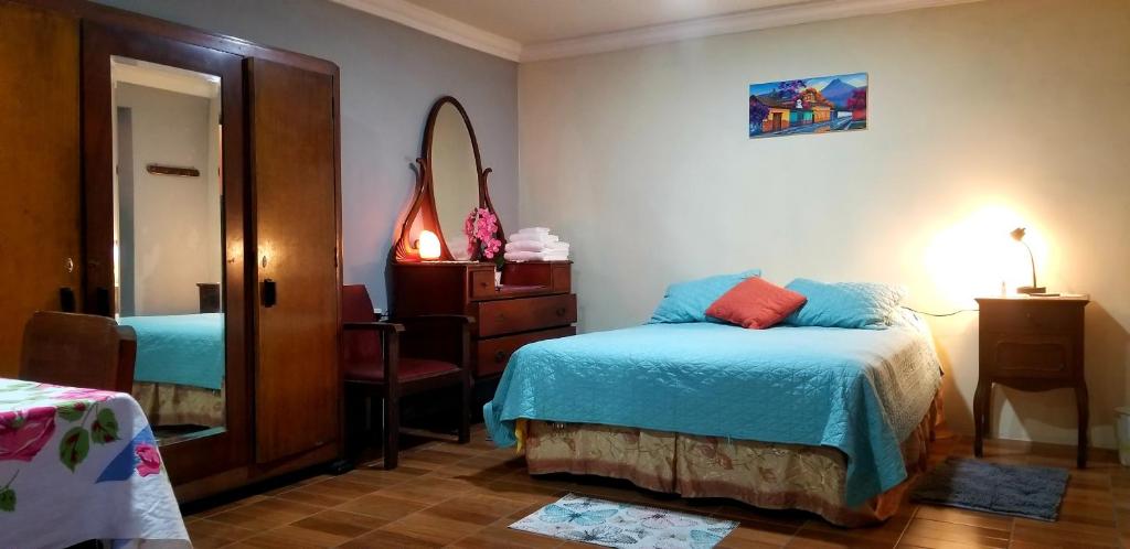 克萨尔特南戈Xelanos的一间卧室配有一张床、梳妆台和镜子