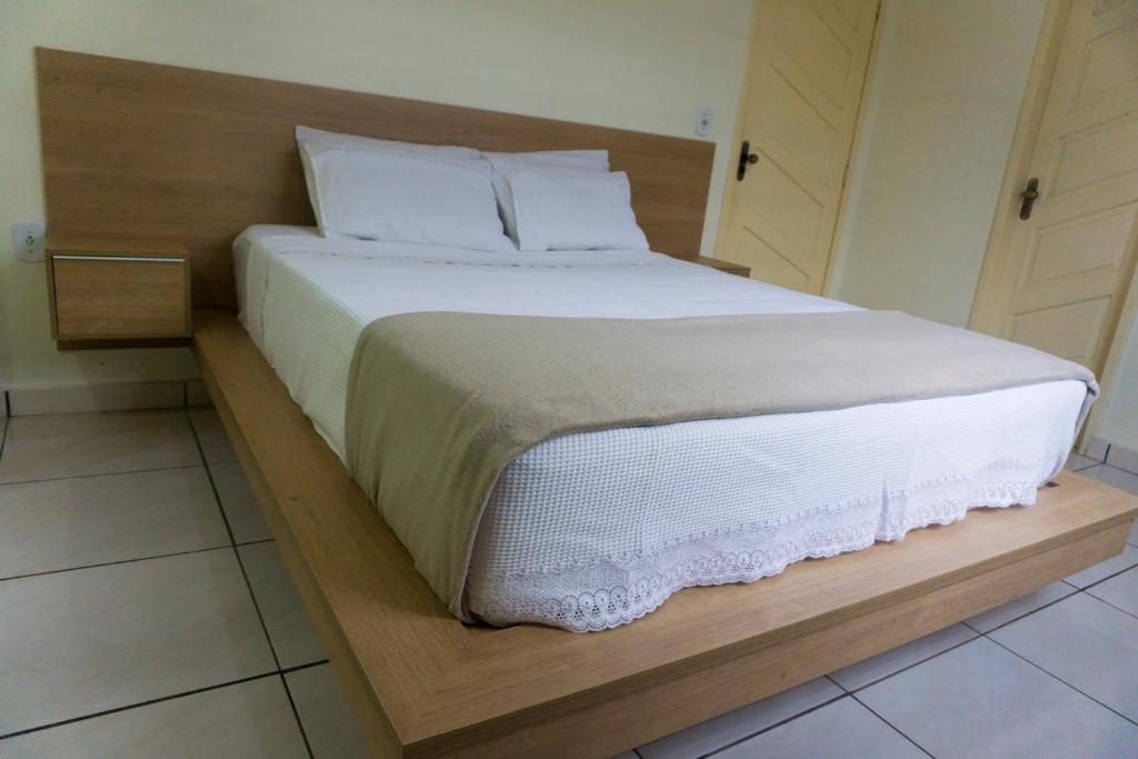 圣塔伦Casa Linda的一张带白色床单和枕头的床